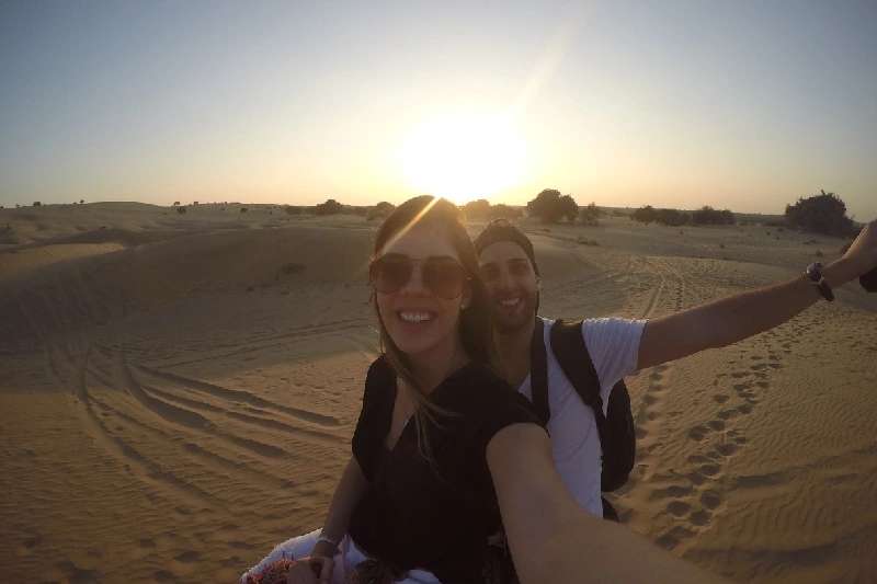 Pareja tomándose un selfie en un camello en el desierto Pareja tomándose un selfie en un camello en el desierto